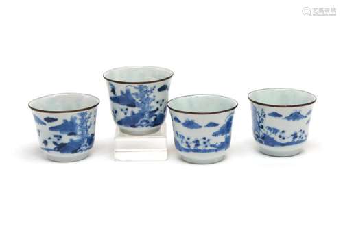 Four blue and white porcelain teacups, each painted with a c...