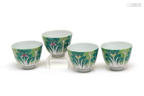 A group of polychrome porcelain teacups, each painted with C...