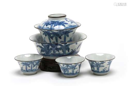 A blue and white porcelain tea set comprising three teacups,...