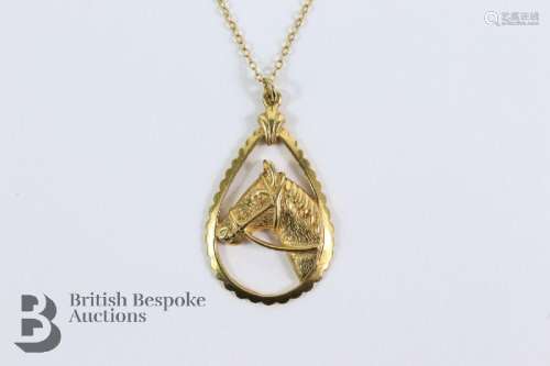 14/15 ct gold pendant of a horse, suspended from a 9ct gold