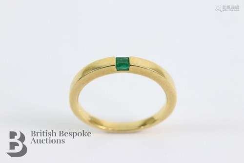 A contemporary 18ct yellow gold and emerald ring. The ring s