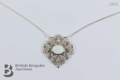 An opal and cubic zircon pendant, suspended from a silver ch