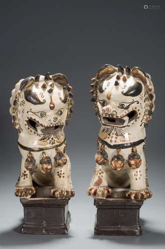 A PAIR OF TRI-COLORED GLAZE LION-FORM CANDLESTICKS