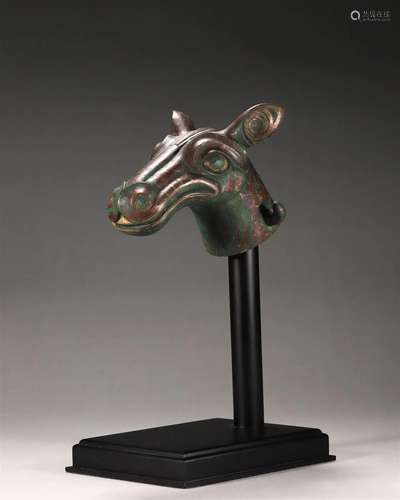 A copper with gold horse head ornament