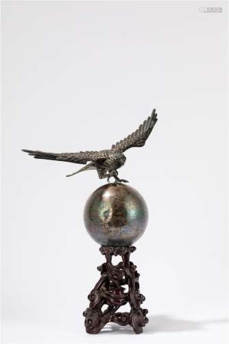 A silver sculpture of a eagle topping the world. China, 20th...
