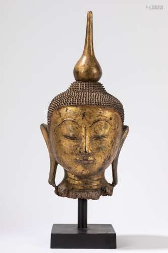 A lacquered and gilt wood head of Buddha. Birmania, 19th cen...