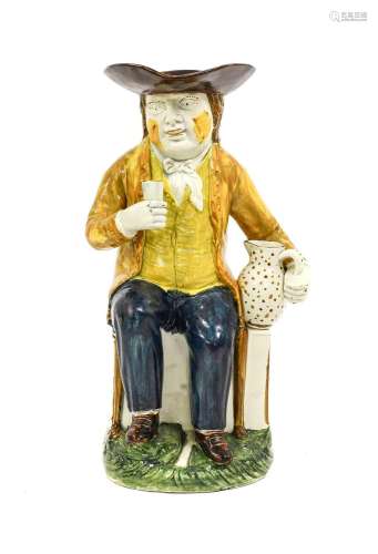 A Prattware Sailor Toby Jug, circa 1795, modelled sitting on...