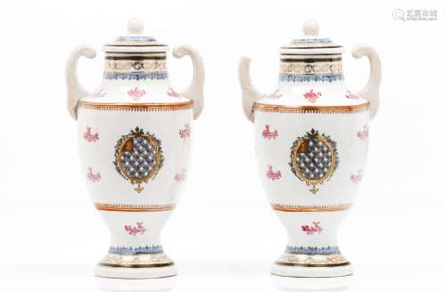 A pair of armorial urns with covers