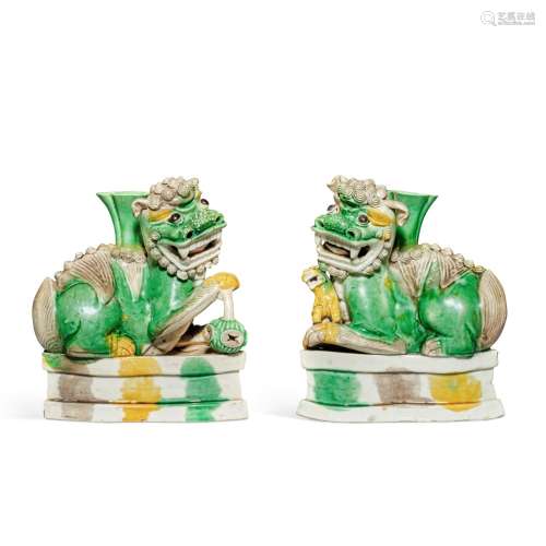 A pair of famille-verte biscuit 'Buddhist Lion' candle holde...
