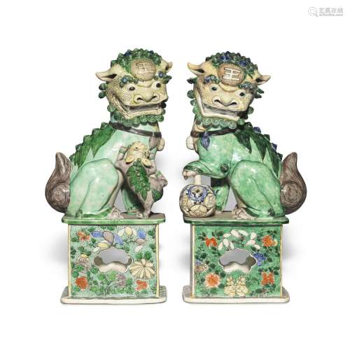 A large pair of famille-verte biscuit Buddhist lions, Qing d...