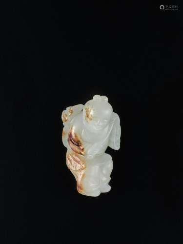 A white and russet jade figure of a boy and lotus, Late Ming...