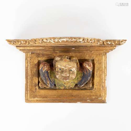 A wood-sculptured wall console with a figurine of an angel. ...
