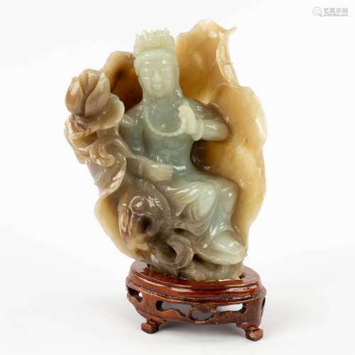 A Chinese, bicoloured Jade figurine of Guan-yin in a lotus f...