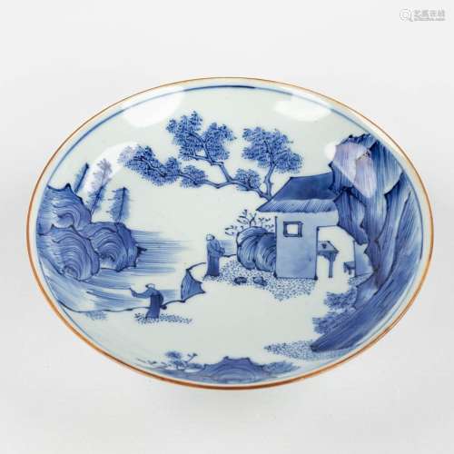 A Chinese bowl with a blue-white mountain landscape and figu...