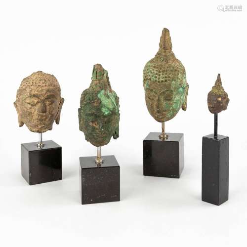 Four 'Heads of Buddha' mounted on a marble base. (H:16 cm)
