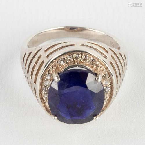 A ring with a large facetted stone, probably a sapphire, sil...