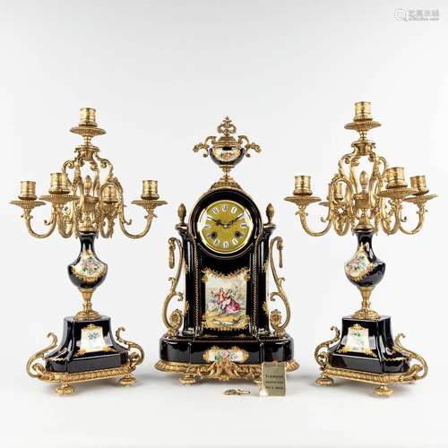 A three-piece mantle garniture clock with candelabra, porcel...