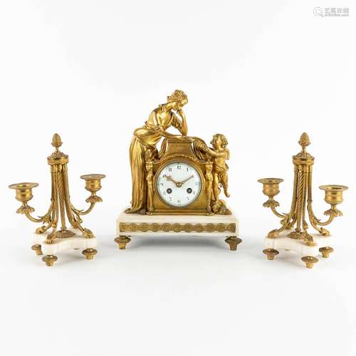 A three-piece mantle garniture clock and candelabra, gilt br...