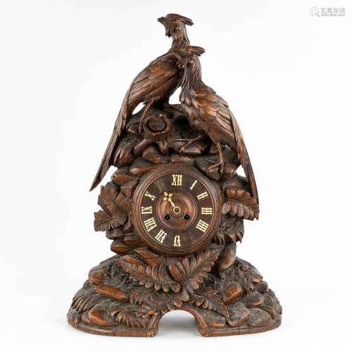 An antique 'Black Forest' mantle clock, decorated with sculp...