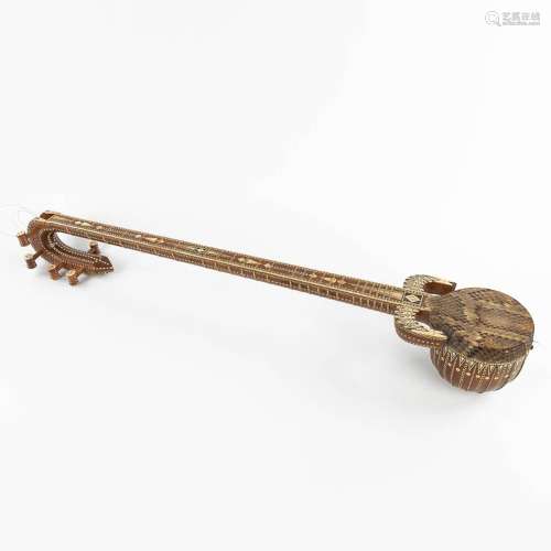 An oriental musical instrument with 6 strings, snake leather...