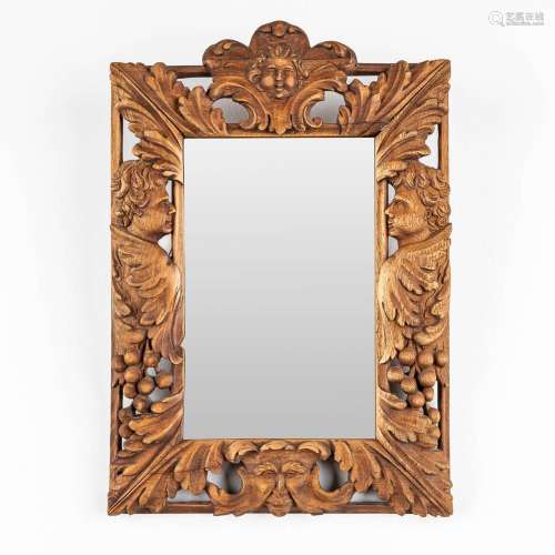 A mirror with wood-sculptured angels and mythological figuri...