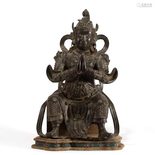 A CHINESE BRONZE SEATED GUARDIAN