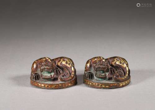 A pair of gold-inlaid bronze dragon paperweights