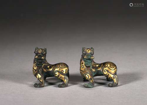 A pair of gold-inlaid bronze beasts