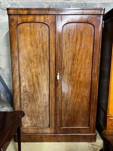 A Victorian mahogany wardrobe, enclosed by a pair of arched ...