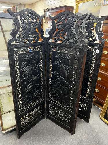 An early 20th century Japanese carved ebonised wood four fol...