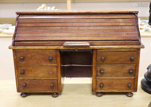 An early 20th century miniature beech tambour pedestal desk,...