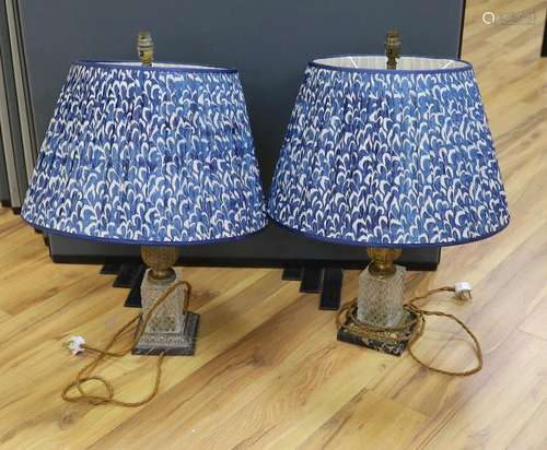 A pair of gilt brass and glass lamps with shades, 71cms high...