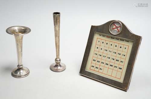 A white metal mounted desk calendar, with inset flag and two...