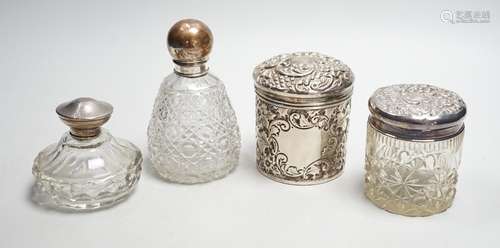 Two repousse silver lidded toilet jars, including glass, lar...