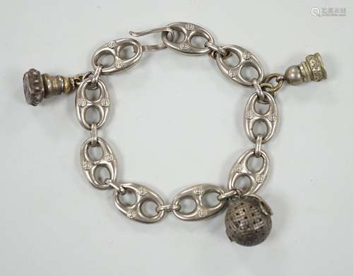 A white metal oval link bracelet, hung with three charms, in...