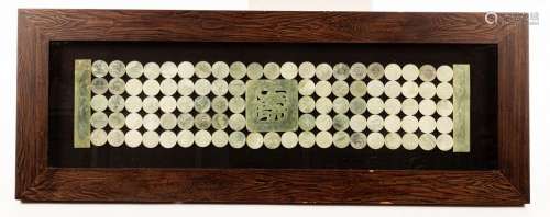 A large banner of jade roundels in a wooden flamed glass cas...