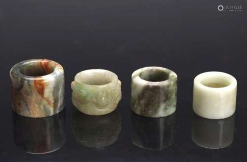 FOUR JADE AND JADEITE ARCHER'S RINGS