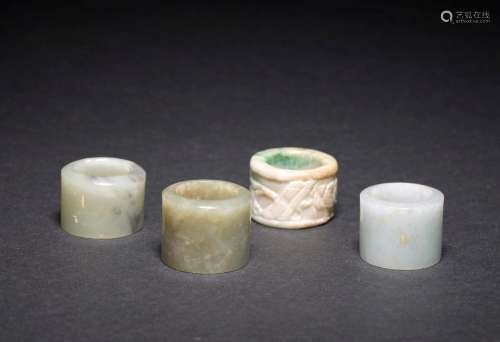 FOUR JADE AND JADEITE ARCHER'S RINGS