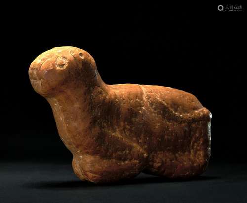 A PREHISTORIC STONE FIGURE OF A RECUMBENT CALF PALEOLITHIC T...