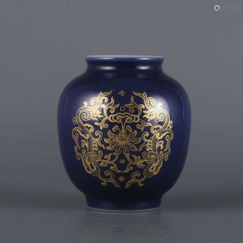 A small pot with blue glaze and golden dragon pattern