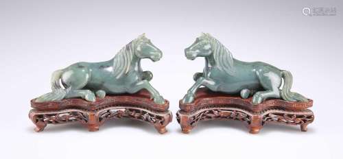 A PAIR OF CHINESE SPINACH JADE MODELS OF RECUMBENT HORSES