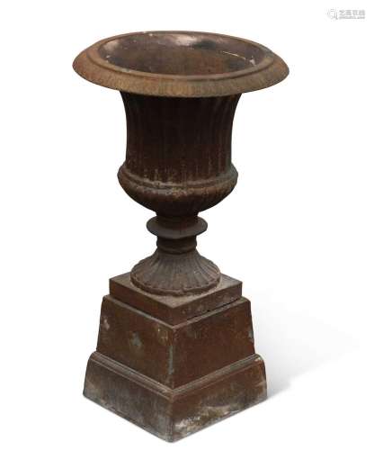 A SMALL CAST IRON URN ON STAND