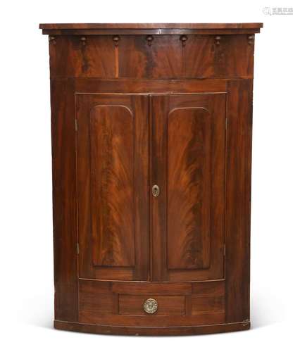 A LARGE REGENCY MAHOGANY BOW-FRONT HANGING CORNER CUPBOARD