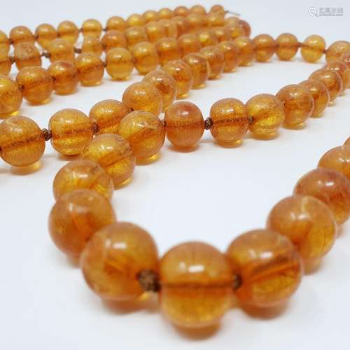 An amber bead necklace consisting of 106 beads, and a painte...