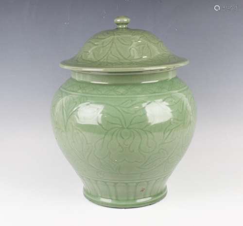 A Chinese carved celadon glazed jar and domed cover