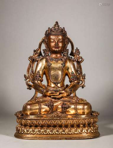 A Qing Dynasty Buddha statue inlaid with gemstones and gilde...