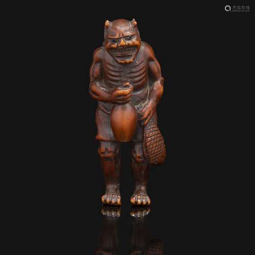 NETSUKE en bois représentant un oni debout, un poisson et un...