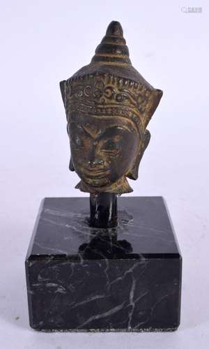 AN 18TH CENTURY CAMBODIAN BRONZE BUDDHA HEAD upon a marble b...