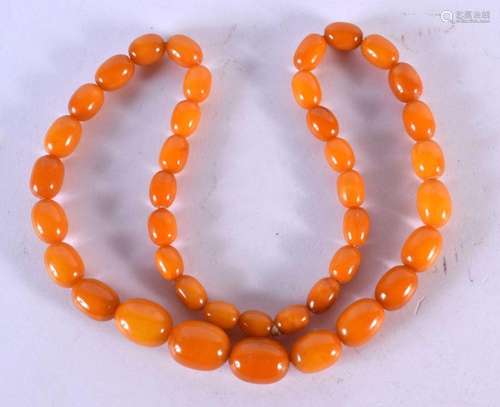 AN ART DECO ORANGE AMBER TYPE NECKLACE. 51 grams. 60 cm long...