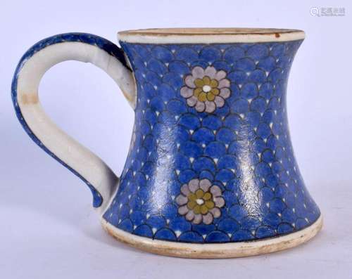 A TURKISH IZNIK POTTERY MUG painted with floral roundels. 15...